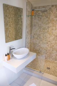a bathroom with a sink and a glass shower at Amber Light Wilderness Beach Cottage in Wilderness +25 photos