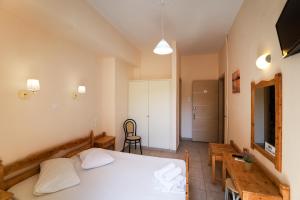 ein Schlafzimmer mit einem Bett, einem Tisch und einem Stuhl in der Unterkunft Europe Hotel in Korfu-Stadt