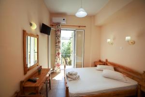 een slaapkamer met een wit bed en een raam bij Europe Hotel in Corfu-stad
