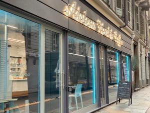 un avant de magasin avec une chaise bleue dans la fenêtre dans l'établissement Adalesia Hotel & Coffee, à Turin