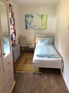 - une chambre avec un lit blanc et un miroir dans l'établissement Bungalow 3, à Wyk auf Föhr