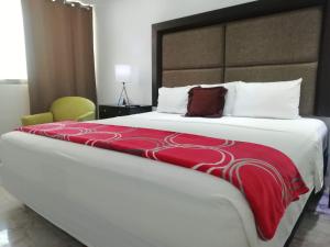 um quarto com uma cama grande e um cobertor vermelho em Hotel Green 16 em Cancún