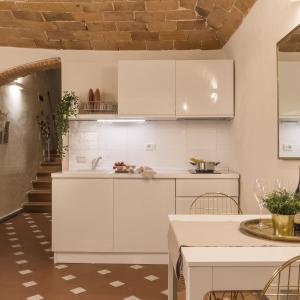 kuchnia z białymi szafkami i stołem w obiekcie Montebello New Apartment we Florencji +23 zdjęcia