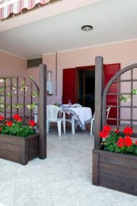 a patio with a table and red flowers in boxes at Casa Campanina in Agropoli