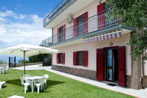 un patio con una mesa y una sombrilla y un edificio en Casa Campanina, en Agropoli