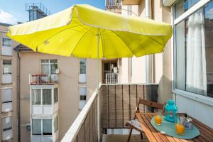 ブダペストにあるRakoczi Apartmentsのバルコニーに黄色い傘付きのテーブル