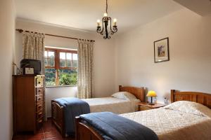 1 dormitorio con 2 camas y ventana en Casa da Eira, en Lousã