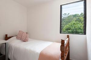 a bedroom with a bed and a window at Cuarto en las Lomas in Mexico City
