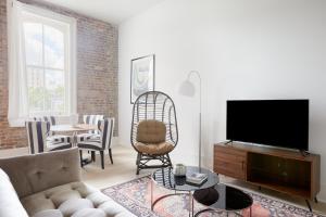 a living room with a couch and a flat screen tv at Sonder Gravier Place in New Orleans