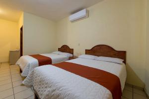 A bed or beds in a room at Hotel y Restaurante Villas Del Sol Jalpan