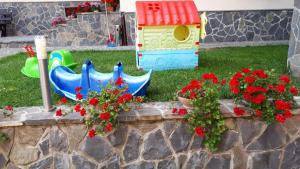 een tuin met een speelgoedhuis en bloemen bij Casa Tad in Buşteni
