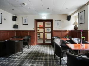 a restaurant with tables and chairs and a door at The Breadalbane Arms Room Only Hotel in Aberfeldy