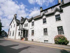 a white building on the side of a street at The Breadalbane Arms Room Only Hotel in Aberfeldy