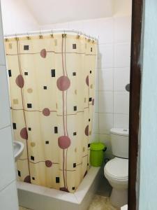 a bathroom with a toilet and a shower curtain at Peaceful Ocean View Studio in San Felipe de Puerto Plata