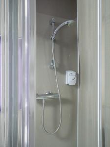 a shower in a bathroom with a glass door at The Breadalbane Arms Room Only Hotel in Aberfeldy