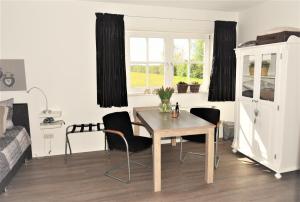 a room with a table and chairs and a bed at De Beddestee in Ruinen