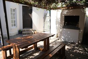 a wooden picnic table sitting outside of a house at Amber Light Wilderness Beach Cottage in Wilderness