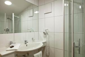 biała łazienka z umywalką i prysznicem w obiekcie Hotel Garni Rifflsee w mieście St. Leonhard im Pitztal +37 zdjęć