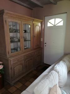 a living room with a wooden cabinet and a door at Rainbow Lodge in Ursel