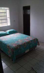 a bedroom with a bed with a blue comforter at CHÁCARA SANTA TERESA in Triunfo