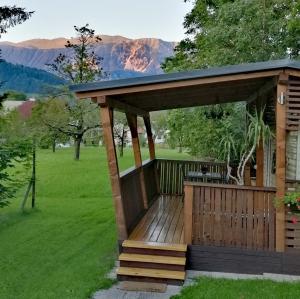 a wooden gazebo with a table in a field at Samson mobile house in Bled