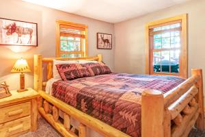 a log cabin bedroom with a bed and windows at The Musky Lodge in Eagle River