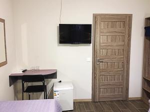 Zimmer mit einem Bett, einem Schreibtisch und einer Tür in der Unterkunft 7Days in Hadyach