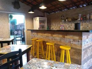 a bar with yellow stools in a restaurant at Pousada Refúgio D´Mar in Ubatuba