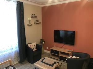 sala de estar con TV de pantalla plana en la pared en Comme à la maison, en Boulogne-sur-Mer