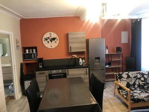 cocina con mesa y reloj en la pared en Comme à la maison, en Boulogne-sur-Mer