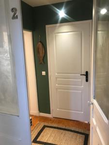 un pasillo con una puerta blanca y una pared verde en Comme à la maison, en Boulogne-sur-Mer
