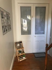 un couloir avec une porte blanche et une plante sur une étagère dans l'établissement Comme à la maison, à Boulogne-sur-Mer
