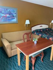 a hotel room with a couch and a table and a bed at Budget Inn & Suites - Talladega in Talladega
