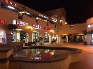 a shopping center with a fountain in front of a building at Valley Hotel in Rosemead