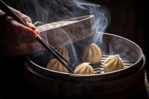 a person is cooking food in a grill with smoke at Valley Hotel in Rosemead