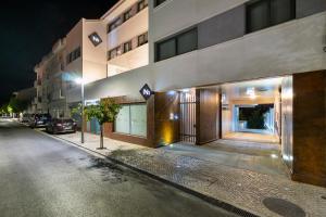 un edificio en una calle de la ciudad por la noche en N1 Hostel Apartments and Suites, en Santarém