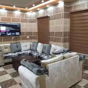 a large living room with couches and a tv at Atoom Hotel in Jerash