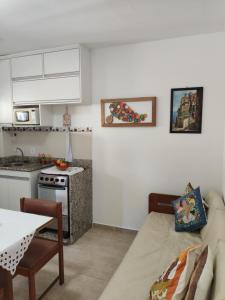 a kitchen and a living room with a couch and a table at Wembley Beach Apto 704 in Ubatuba