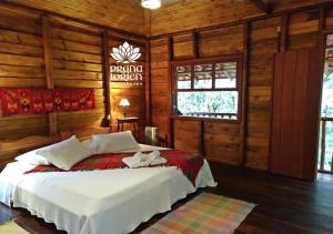 a bedroom with a bed in a log cabin at Pousada Spa Prana Lorien in Santo Antônio do Leite