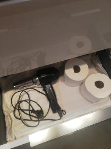 a desk with a charger and two rolls of toilet paper at LOFT A 20' DE BARCELONA Y 7' DE LA UAB. in Barbera del Valles