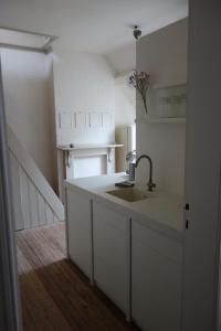 una cucina con lavandino e armadietti bianchi di Studio Minerva ad Anversa