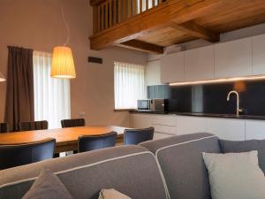 - une cuisine et une salle à manger avec un canapé et une table dans l'établissement 3 Chalets Aparthotel, à Breuil-Cervinia