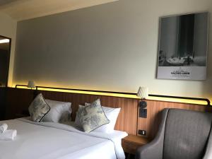 a bedroom with two beds and a chair and a picture on the wall at Hotel Noir in Chiang Mai