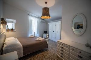 1 dormitorio con cama, espejo y tocador en Bianko EcoChic & L'Angolo di Levante, en Enna