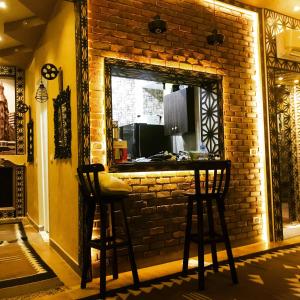 een bar met twee krukken voor een stenen muur bij Heritage Hostel Cairo in Caïro