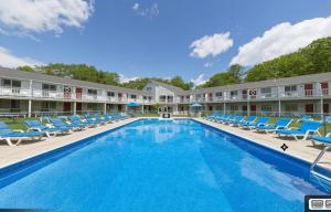 a pool at a hotel with blue lounge chairs at Rhumb Line Resort in Kennebunkport
