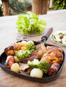 patelnia wypełniona mięsem i warzywami na stole w obiekcie Hotel Fazendão w mieście Santa Branca