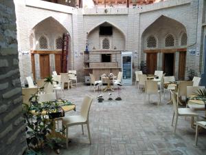 a restaurant with tables and chairs in a building at Aist House in Bukhara