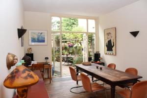 sala de estar con mesa de madera y sillas en Bed & Breakfast Leonie, en La Haya