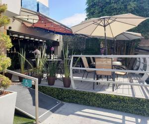 a patio with a table and an umbrella at Hotel Velario in Tijuana